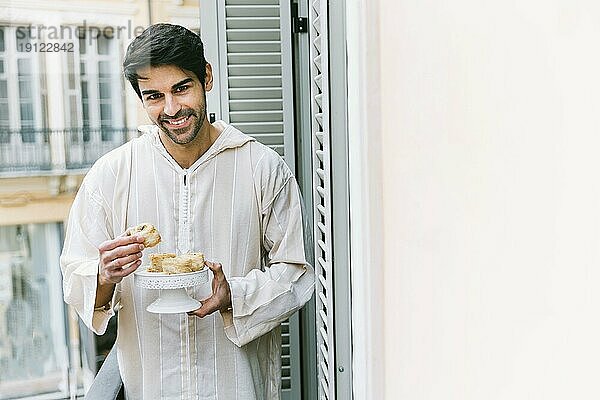 Eid al fitr Konzept mit muslimischem Mann beim Essen