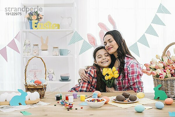 Erfreuliche Mutter umarmt ihre Tochter feiern Ostern Tag