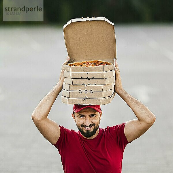 Vorderansicht Zusteller mit Pizzakartons auf dem Kopf