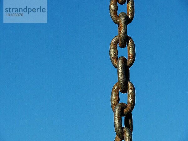 Etwas angerostete Eisenkette  Ausschnitt  mit blauem Himmel als Hintergrund