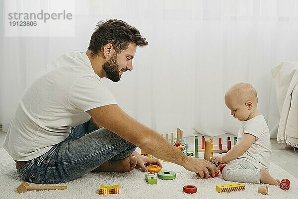 Vater lehrt Baby spielen mit Spielzeug zu Hause