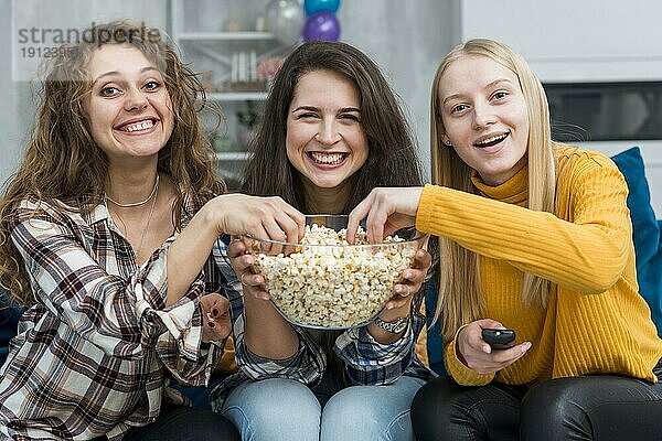 Freunde schauen einen Film und essen Popcorn