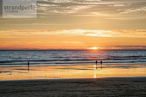 Sonnenuntergang über dem Atlantik mit der Silhouette eines Fotografen  der am Strand von Fonte da Telha  an der Costa da Caparica  Portugal  Bilder von der Brandung macht  Europa