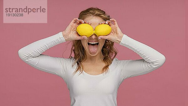 Porträt verspielte Frau hält Zitronen lacht