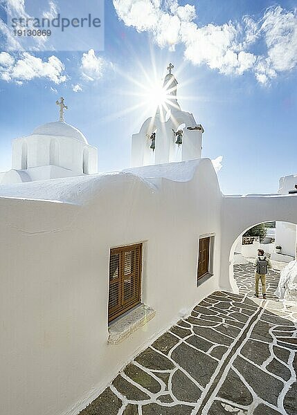 Weiße griechisch orthodoxe Kirche mit Sonnenstern  junger Mann in den malerische Gassen des Ortes Marpissa  Paros  Kykladen  Griechenland  Europa