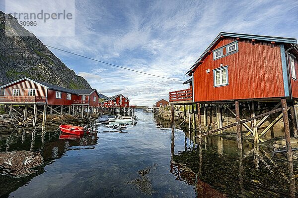 Traditionelle rote Rorbuer Holzhütten  auf Stelzen am Ufer  spiegeln sich im Wasser  Fischerdorf Å i Lofoten  Lofoten  Nordland  Norwegen  Europa