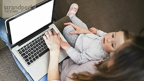 Erhöhte Ansicht Frau mit ihrer Tochter mit Laptop mit leeren weißen Bildschirm