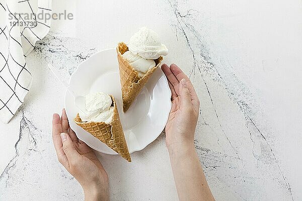 Hände halten Teller mit leckerem Dessert