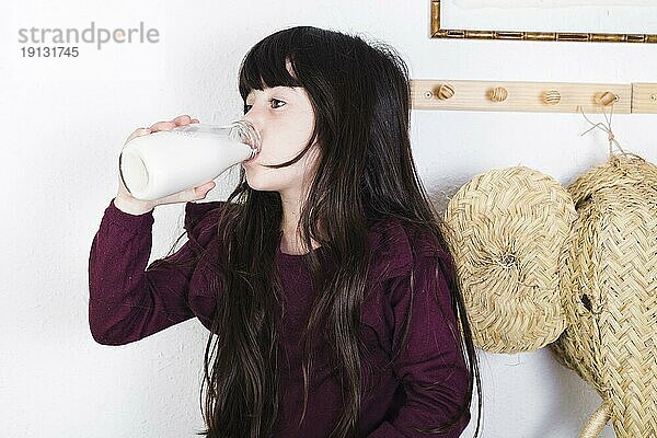 Mädchen trinkt Milch aus der Flasche
