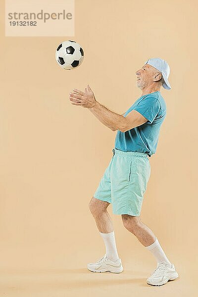 Moderner älterer Mann mit Fußball