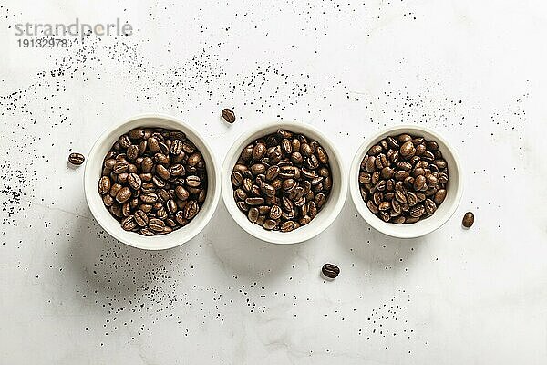 Draufsicht auf drei Tassen mit gerösteten Kaffeebohnen
