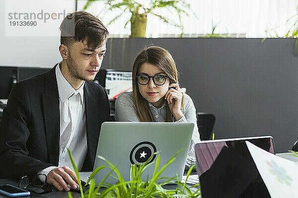 Zwei junge Geschäftsleute am Laptop Arbeitsplatz