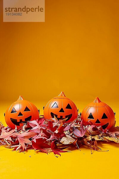 Halloween orange Kürbisse auf einem gelben Hintergrund  Herbst Dekoration