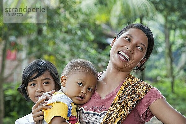 Mutter  lachend  mit Kleinkind und einem weiteren Kind  Lombok  Indonesien  Südostasien  Asien