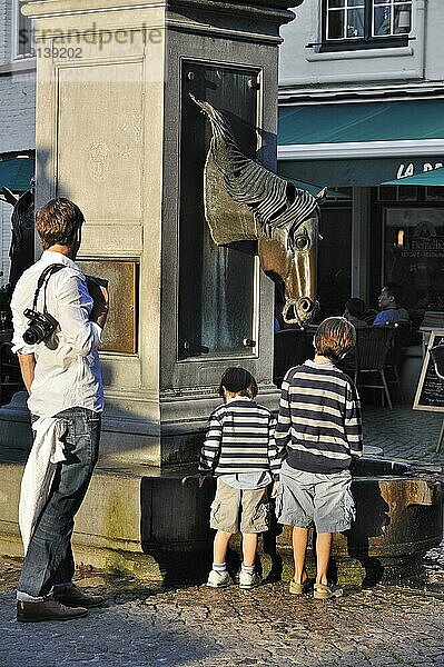 Vater mit zwei Kindern an einer Pferdetränke  Brügge  Belgien  Europa