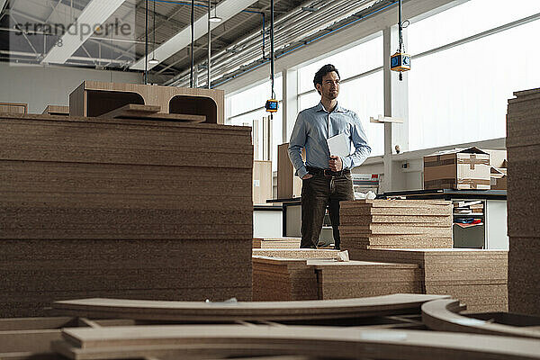 Businessman standing with tablet PC in lumber industry