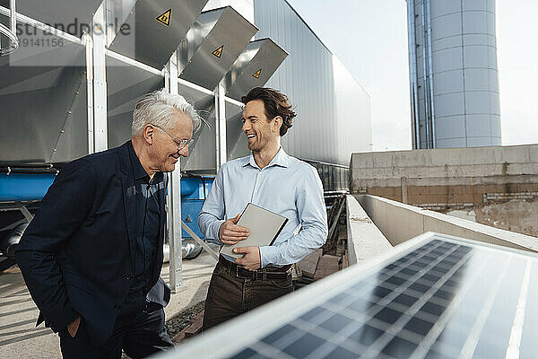 Glückliche Geschäftsleute stehen zusammen am Solarpanel
