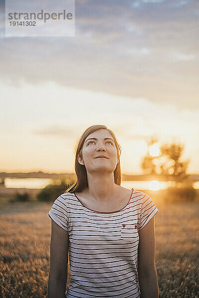 Porträt einer jungen Frau  die sich bei Sonnenuntergang in der Natur entspannt