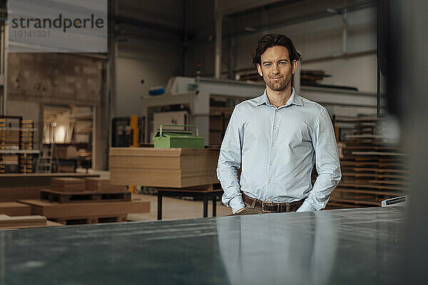 Smiling businessman standing in lumber industry