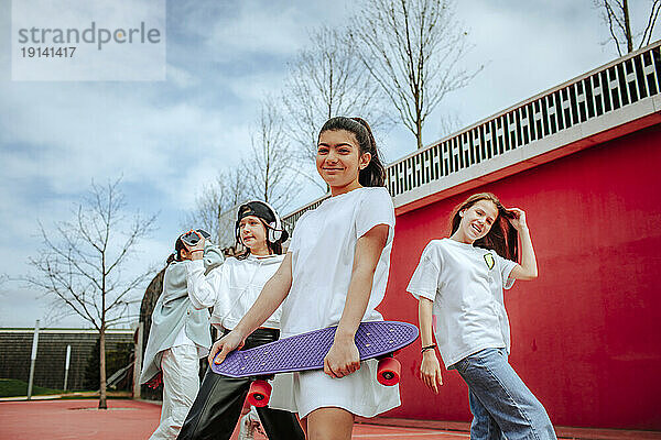 Teenager-Mädchen mit Skateboard verbringt Freizeit auf Spielplatz
