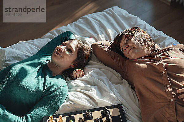 Lächelndes lesbisches Paar entspannt sich zu Hause im Bett