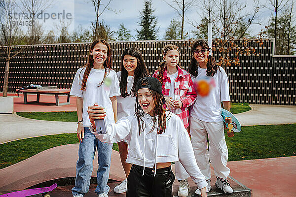 Fröhliche Teenager-Freunde machen Selfie mit Smartphone auf dem Spielplatz
