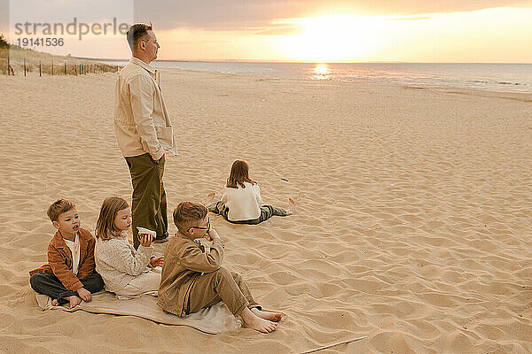 Vater mit Kindern verbringt Zeit am Strand