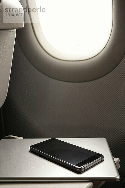 Mobiltelefon und Tablet-PC in der Nähe des Flugzeugfensters