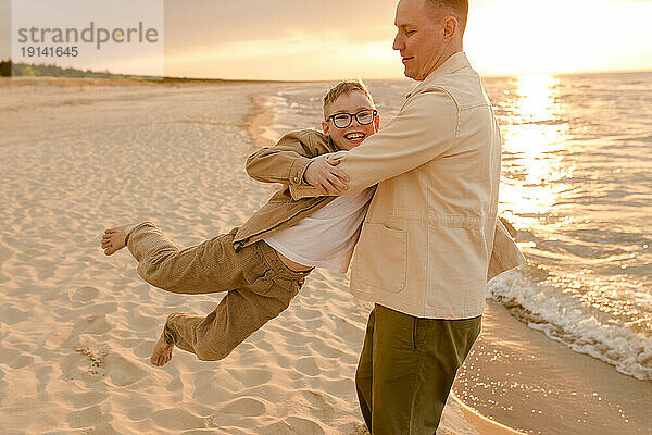 Glücklicher Vater  der Spaß mit seinem Sohn an der Küste am Strand hat