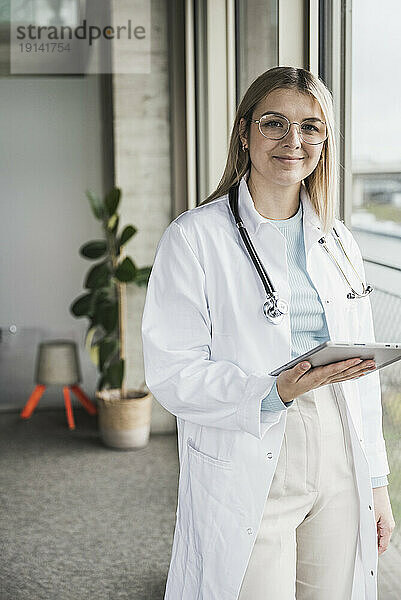 Lächelnde Ärztin hält Tablet-PC im Krankenhaus