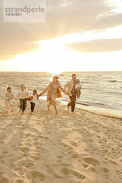 Fröhliche Familie beim Laufen und Spaß am Strand