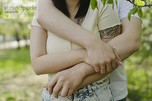 Mann umarmt Freundin im Park