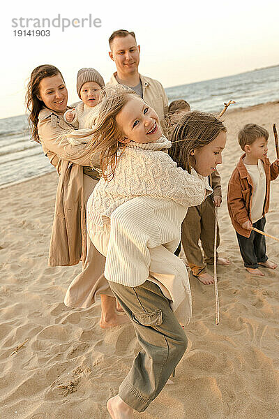 Glückliche Familie  die Spaß am Strand hat