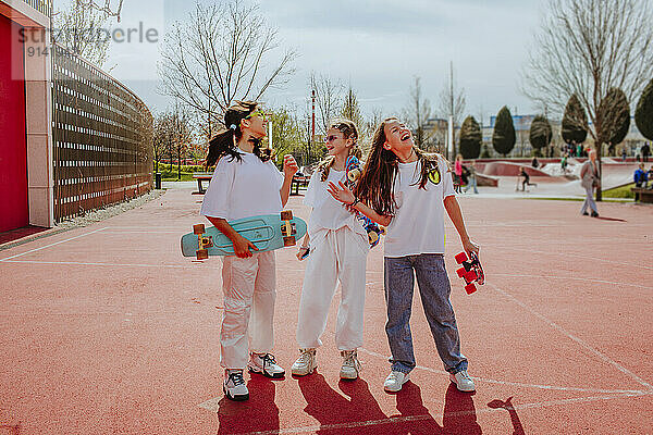 Teenager-Freunde mit Skateboard verbringen ihre Freizeit auf dem Spielplatz