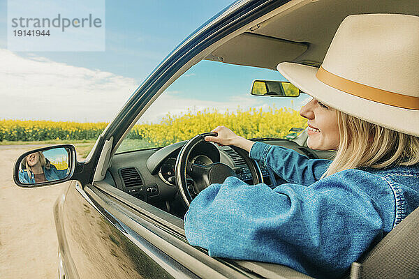 Lächelnde Frau genießt den Roadtrip im Auto