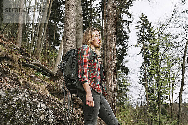 Frau mit Rucksack wandert im Wald