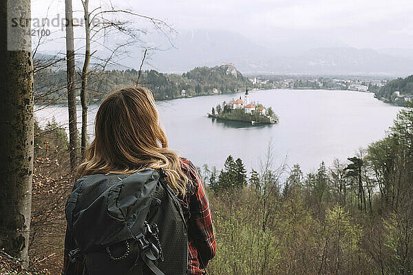 Blonder Wanderer blickt auf das Meer und wandert im Wald