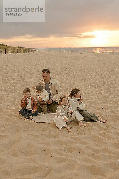 Vater mit Kindern verbringt gemeinsame Zeit am Strand