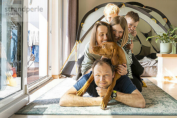 Glückliche Familie verbringt Freizeit mit Vizsla-Hund zu Hause