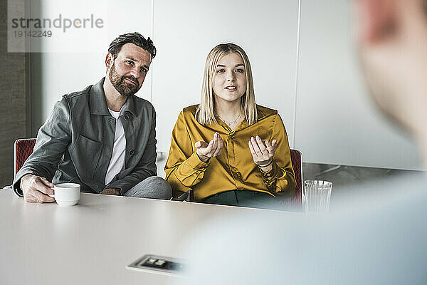 Businesswoman explaining colleague in meeting at office