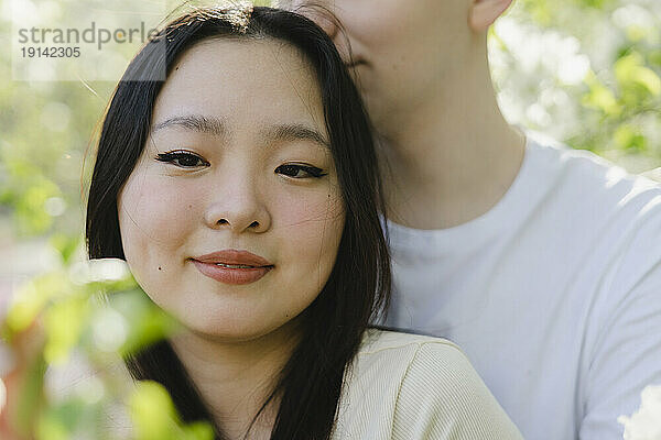 Smiling young woman with boyfriend at park