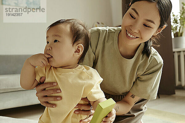 Smiling mother spending leisure time with daughter at home