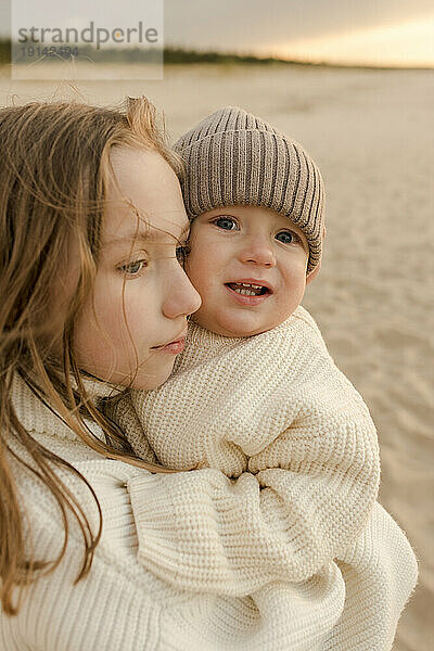 Mädchen mit kleinem Bruder am Strand