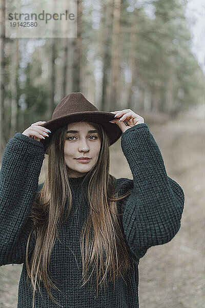 Junge Frau mit langen Haaren und Hut auf dem Feld