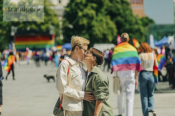 Liebevolles lesbisches Paar küsst sich bei Gay-Pride-Event