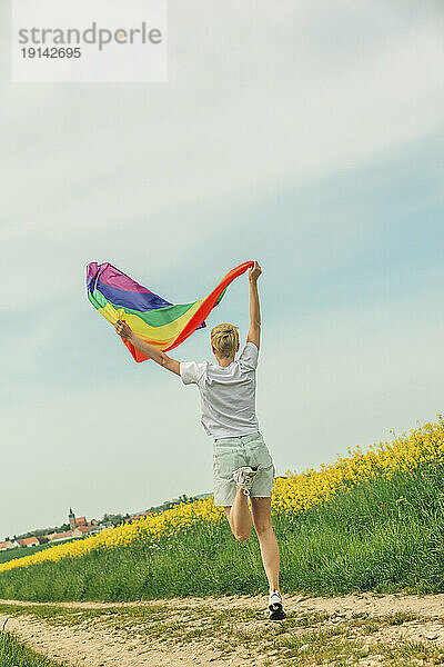 Fröhliches lesbisches Springen mit Regenbogenfahne