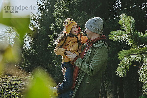Fröhlicher Vater und Tochter haben Spaß im Wald