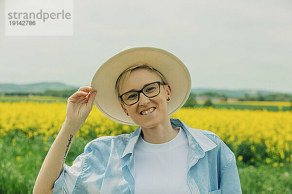 Glückliche Frau mit Hut auf dem Feld