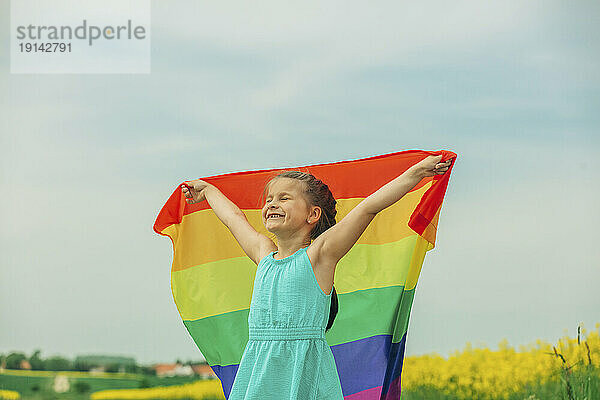 Happy girl holding rainbow flag