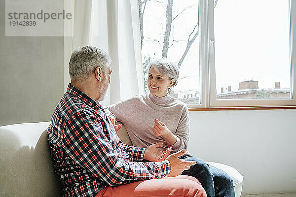 Glückliches älteres Paar  das zu Hause sitzt und redet